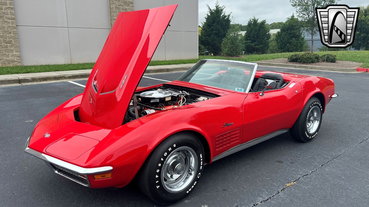 A red convertible car with the hood open

Description automatically generated