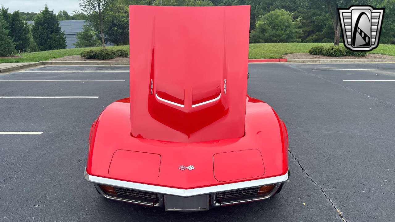 A red car with a hood

Description automatically generated